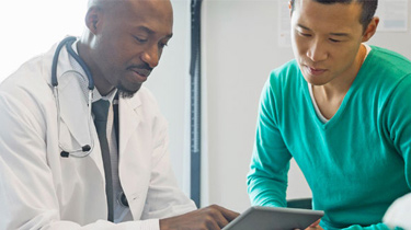 Doctor and patient looking at information on a mobile device 